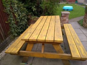 A freshly painted and washed yellow bench. It still lokks tired but is brighter than it was.