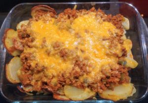 A rectangle pyrex dish with cooke sliced potatoes and loaded with a mince and lentil meal (sloppy joe recipe) covered in melted orange cheese. Looks filthy but was delicous.